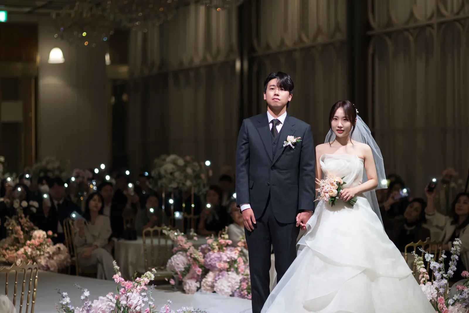 리버사이드 웨딩홀본식사진 어두운 홀에서 입장하는 신랑신부